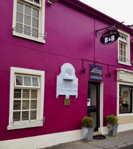 um edifício roxo com um sinal de bar em Canice Mooney Self Catering Holiday Home em Drumshanbo