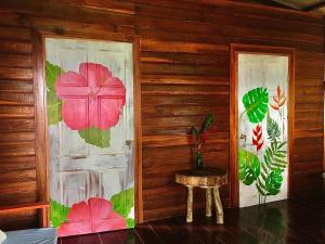 Habitación con 2 puertas pintadas de flores. en True Nature Jungle House en Bastimentos