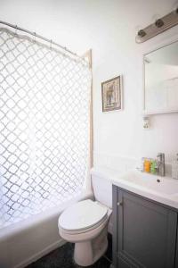 a white bathroom with a toilet and a sink at Birmingham Home/2BR/Close to everything! in Birmingham