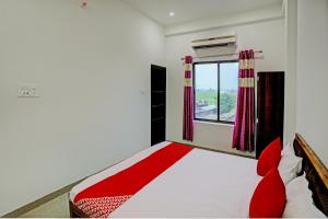 a bedroom with a bed and a window at OYO Flagship Hotel Bhardwaj in Varanasi