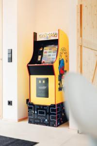 una máquina de videojuegos en una habitación en Premium Ferienhaus Das Farmhaus - Auf den Moselhöhen - Pool, Sauna, Kino, Garten, en Lieg