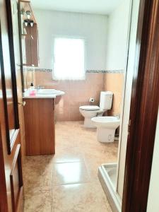 ein Badezimmer mit einem Waschbecken, einem WC und einer Badewanne in der Unterkunft Apartamento Obao in Ribadeo