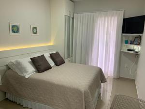 um quarto com uma cama com duas almofadas e uma janela em Pousada Mar de Cristal em Florianópolis