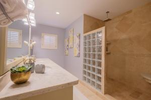 a bathroom with a shower and a sink and a tub at Ocean's Edge Belize in San Pedro