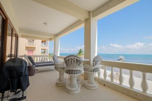 Un balcón con sillas y vistas al océano. en Ocean's Edge Belize, en San Pedro