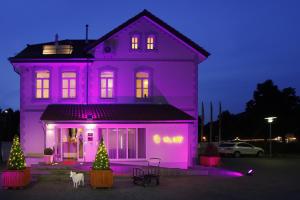 una casa púrpura con un perro delante de ella en Hotel Villa Will, en Hannover