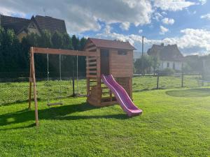 a small playground with a slide and a play house at Apartamenty u Petuski z Jacuzzi in Szaflary
