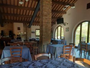 um restaurante com mesas e cadeiras azuis e janelas em Agriturismo Antica Corte em Montatteglia