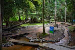 um parque com um rio com pedras e uma placa em IKOGOSI WARM SPRINGS RESORT em Ikogosi