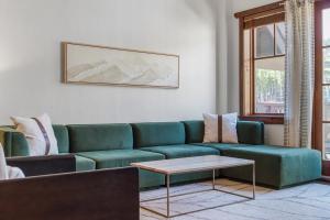 a living room with a green couch and a table at Penthouse in One Ski Hill in Breckenridge