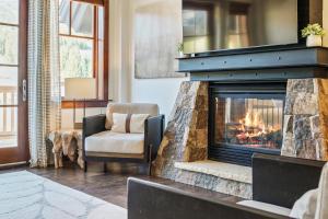 a living room with a fireplace and a chair at Penthouse in One Ski Hill in Breckenridge +45 photos