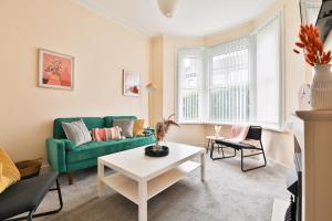 a living room with a green couch and a table at StayRight 3-Bed Home Near Central Cardiff- Sleeps 8, Twin Or King Beds in Cardiff