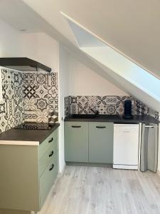a kitchen with white cabinets and a staircase at Le petit Saint Vincent, Neuf et calme in Lorcy +2 photos