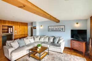 a living room with a large couch and a tv at Harrison Getaway with Deck and Lake Views! in Harrison
