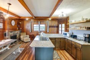 a kitchen with wooden cabinets and a counter top at Harrison Getaway with Deck and Lake Views! in Harrison