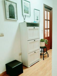 eine weiße Kommode mit schwarzem Stuhl in einem Zimmer in der Unterkunft Apartamento Obao in Ribadeo