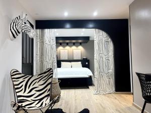 a zebra themed bedroom with a bed and a chair at Chez Hervé et Nicky in Charleville-Mézières