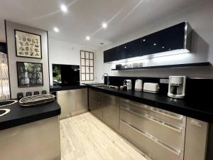 a kitchen with stainless steel appliances and black counter tops at Chez Hervé et Nicky in Charleville-Mézières