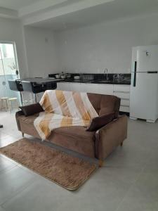 - un salon avec un canapé et une couverture dans l'établissement Sobrado Itajuba, à Barra Velha
