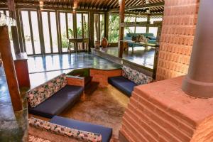- un salon avec des canapés et des tables dans un bâtiment dans l'établissement Casa Praia da Feiticeira Condomínio Fechado, à Ilhabela