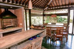 cocina con encimera, mesa y sillas en Casa Praia da Feiticeira Condomínio Fechado, en Ilhabela