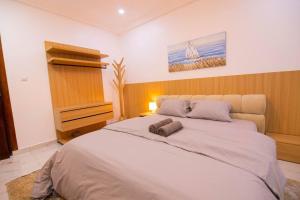 a bedroom with a large bed and a dresser at Big chill stays East Legon in Accra