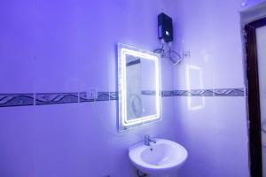 a white bathroom with a sink and a mirror at Big chill stays East Legon in Accra