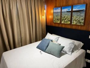 ein Schlafzimmer mit einem Bett mit zwei Kissen darauf in der Unterkunft Salvador farol da barra 01 Apartamento Vista Mar in Salvador