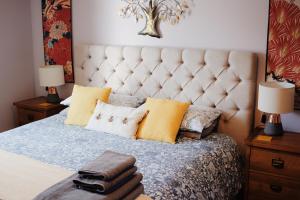 a bedroom with a large bed with yellow pillows at Little Lodge on the Yorkshire Wolds in York