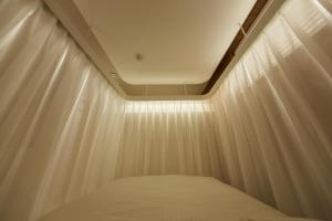 a bed in a room with white curtains at Maruka Osaki Room C - Vacation STAY 53141v in Tokyo