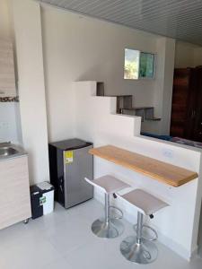 uma cozinha com um balcão e dois bancos de bar em Aparta estudio 3 em Santa Marta