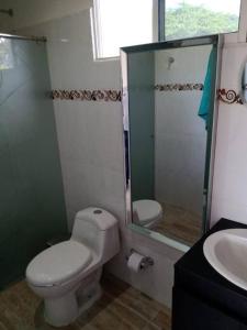 uma casa de banho com um WC, um chuveiro e um lavatório. em Aparta estudio 3 em Santa Marta