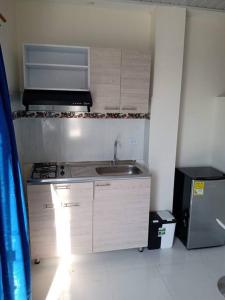 uma pequena cozinha com um lavatório e um fogão em Aparta estudio 3 em Santa Marta