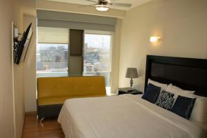 a bedroom with a large bed and a window at Puerta Alameda Suites México in Mexico City