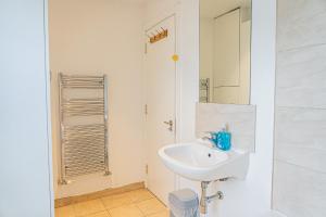 a white bathroom with a sink and a shower at Hackney Central Houseshare in London