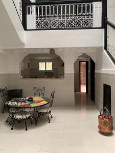 a dining room with a table and chairs and a staircase at Riad lalla aicha in Marrakech