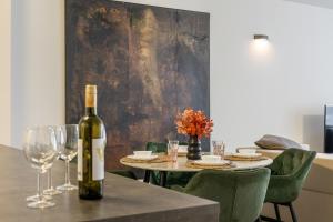 a bottle of wine sitting on a table with wine glasses at BNB SK Zámocká Artist Apartment in Bratislava