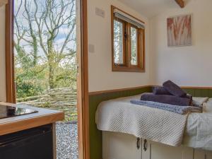 a room with a bed and a window in a kitchen at Uk41330 Wampford Woodland Retreat - Kates Cabin in George Nympton