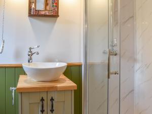 a bathroom with a sink and a shower at Uk41330 Wampford Woodland Retreat - Kates Cabin in George Nympton