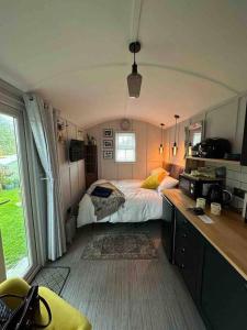 a bedroom with a bed in a room with a window at Beautiful shepherd’s hut in Newmarket
