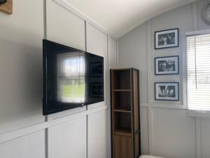 a living room with a flat screen tv on a wall at Beautiful shepherd’s hut in Newmarket