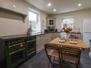 a kitchen with a green stove and a wooden table at 20 Wool Road in Oldham