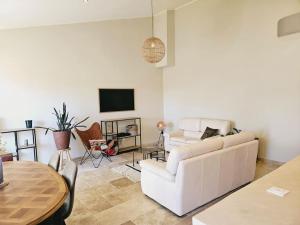 蒙布舍叙尔雅布龙Le gîte de la marquise - Elégant appartement avec terrasse -的客厅里有一张白色的沙发和一张桌子