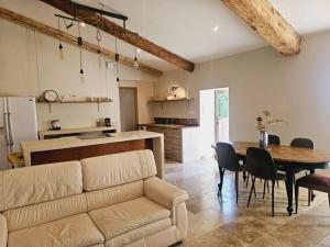 ein Wohnzimmer mit einem Sofa und einem Tisch in der Unterkunft Le gîte de la marquise - Elégant appartement avec terrasse - in Montboucher-sur-Jabron