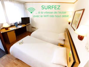 Habitación de hotel con 2 camas y escritorio en Campanile Marmande, en Marmande