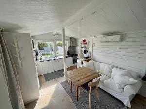 a living room with a white couch and a table at Gästhus vid hav och strand in Åsa