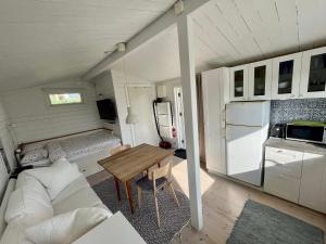 a small room with a table and a couch and a kitchen at Gästhus vid hav och strand in Åsa