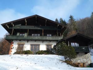 a house on top of a snow covered hill at Waldhofalm Angerer in Berchtesgaden