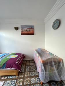 ein Schlafzimmer mit einem Bett und einem Bild an der Wand in der Unterkunft Maison Berj in Oualidia