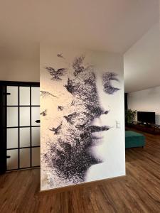 a wall mural of a woman with birds at BoleslaviaApartments - Apartament Arte 2 - parking free, EV in Bolesławiec